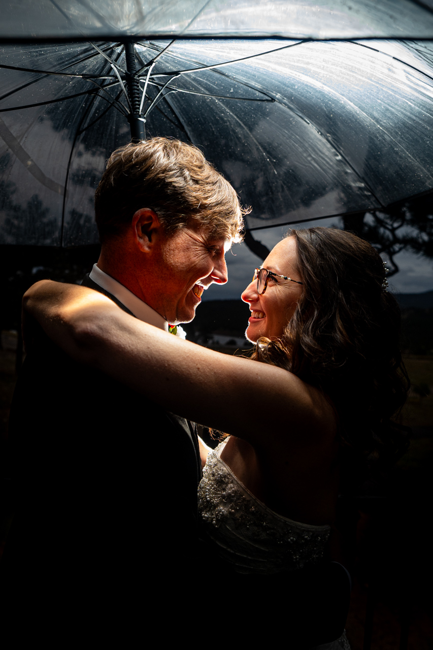 umbrella estes park wedding photographer captures newlyweds under umbrella