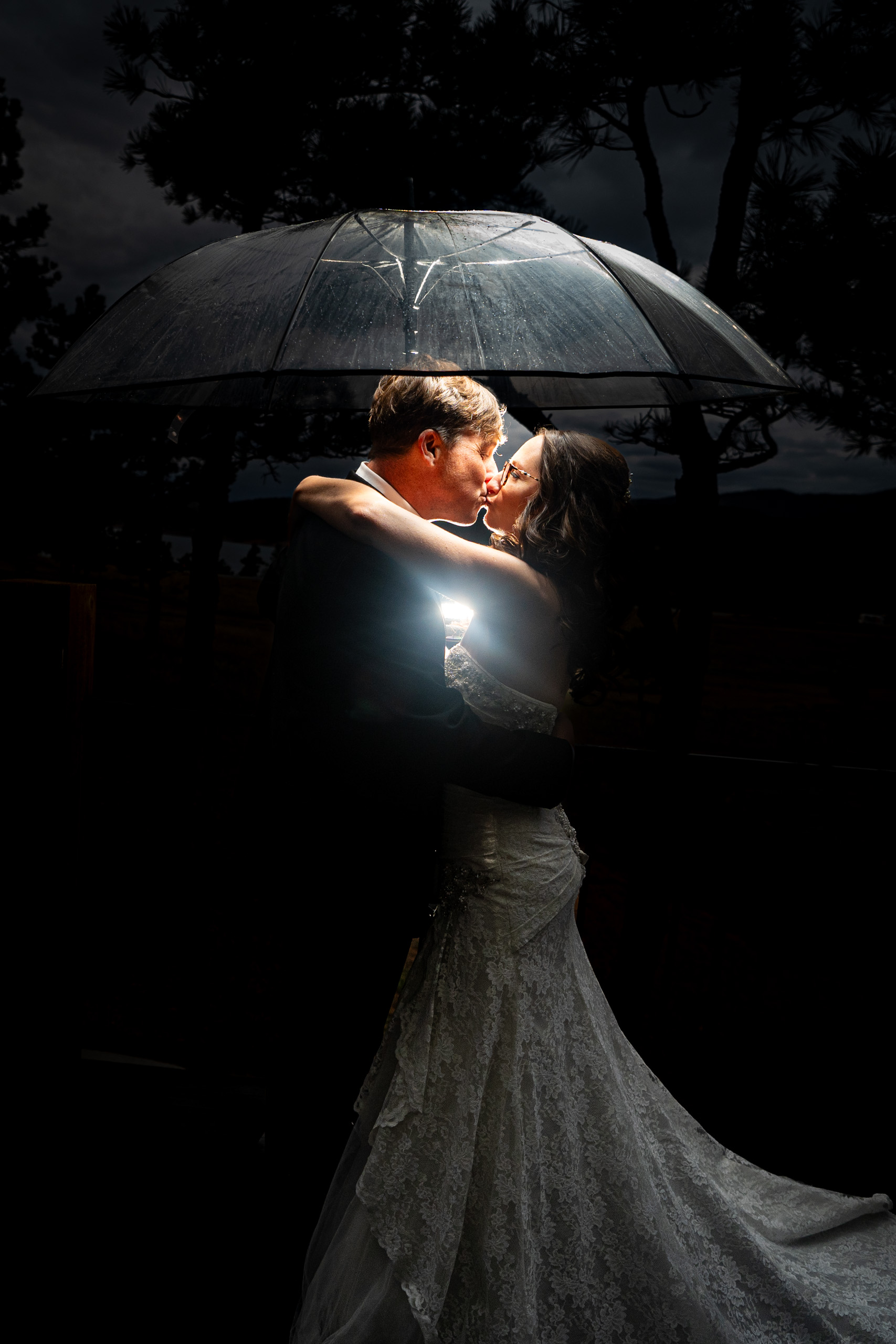 umbrella couple estes park wedding photographer captures couple embracing under umbrella