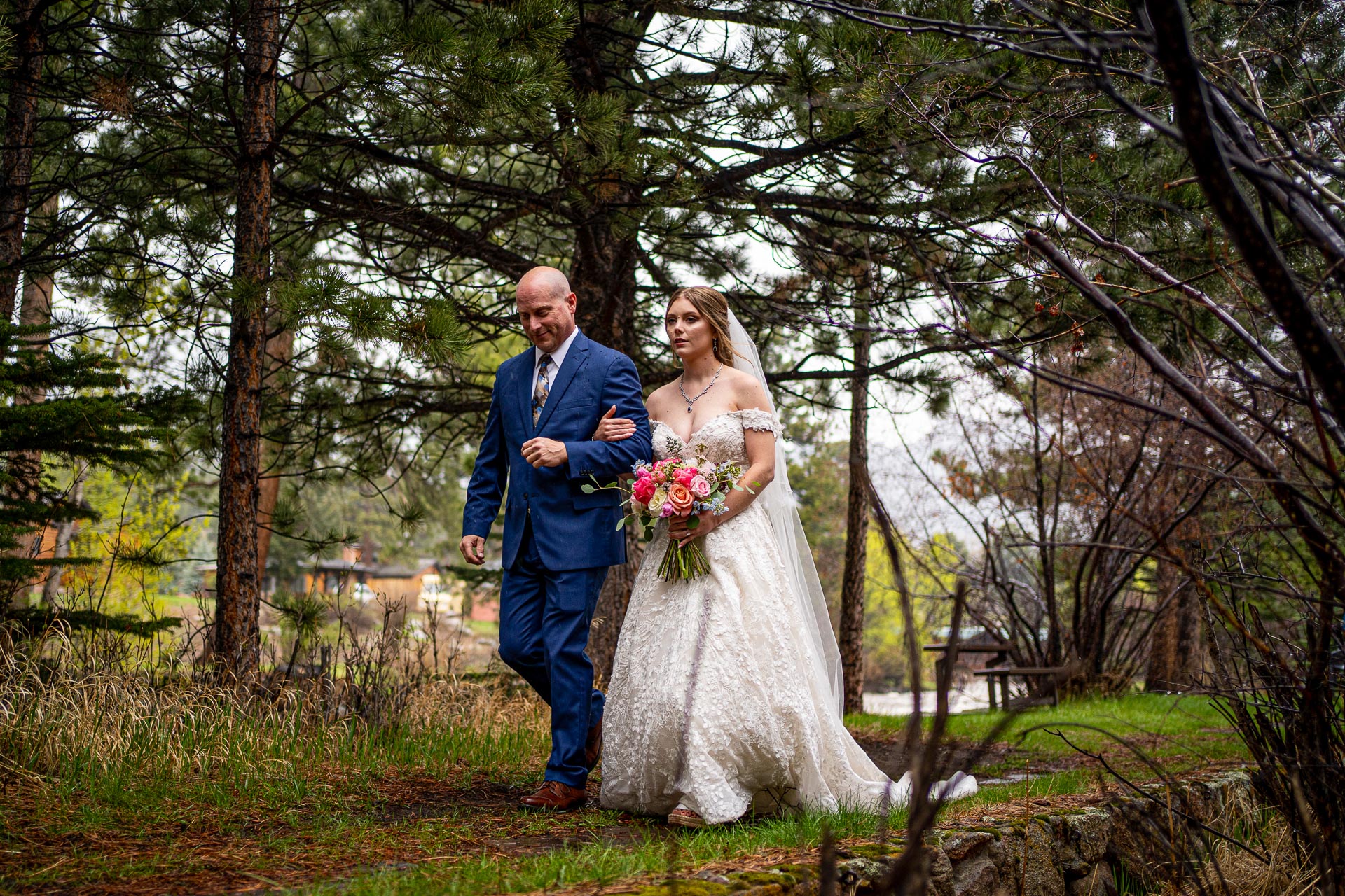 Father of the bride walking with bride to the ceremony location at the Riversong Inn Retreat, Estes Park Colorado