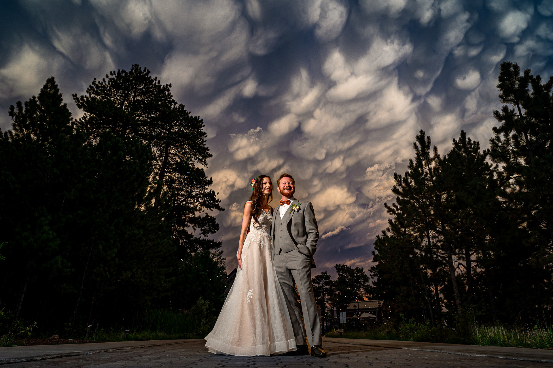 Estes Park Wedding Photographer, Pyle Photography, captures couple standing below a beautiful display of clouds and weather in Estes Park, Colorado