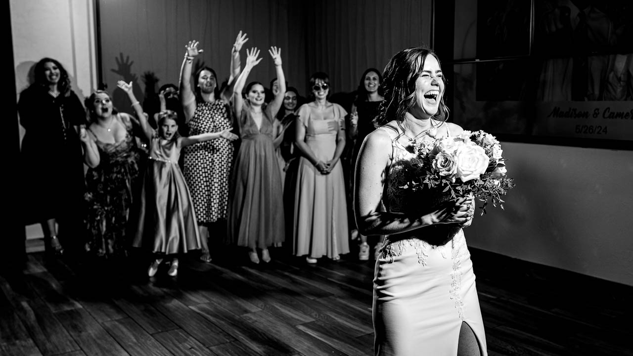 Bride getting ready to throw her bouquet to her bridesmaids at the Black Canyon Inn, captured by Estes Park photographer, Joe Pyle Photography
