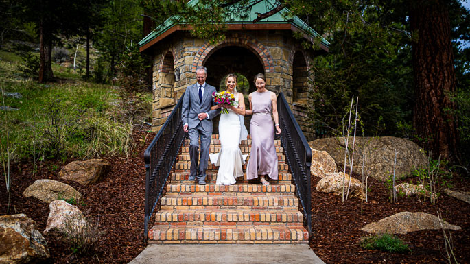 estes Park wedding photographer, Joe Pyle Photography, captures bride, father, and mother walking to her groom